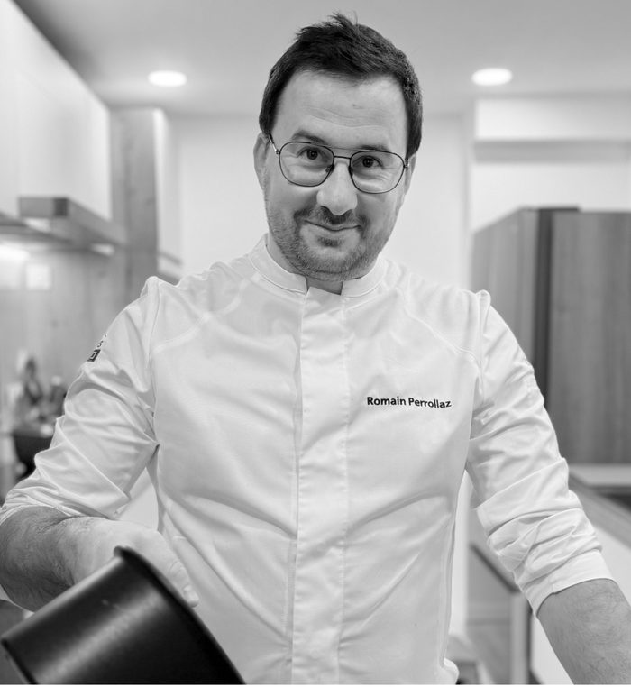 Portrait de Romain Perrollaz, chef privé, en veste de cuisine dans sa cuisine à Nice
